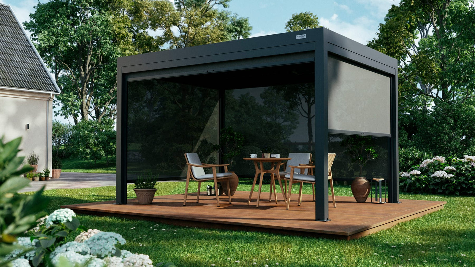 Anthracite grey PERGOLUX pergola with glass walls and roller screens on a wood deck in a green residential garden, midday.